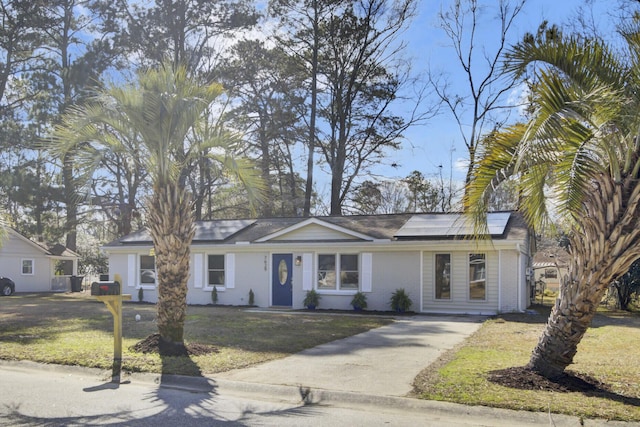 ranch-style house featuring roof mounted solar panels, a front lawn, and brick siding