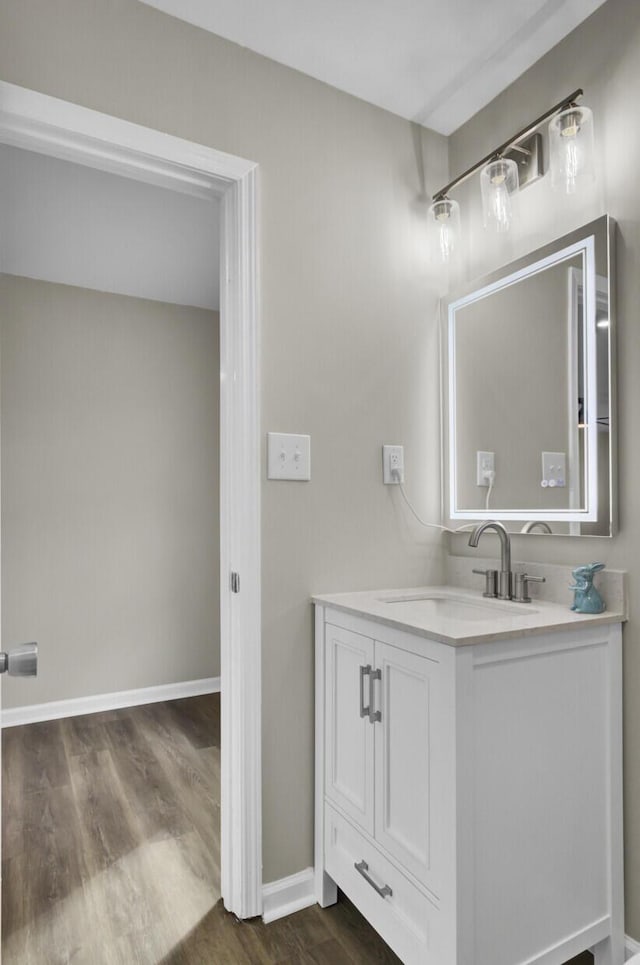 bathroom featuring vanity, baseboards, and wood finished floors