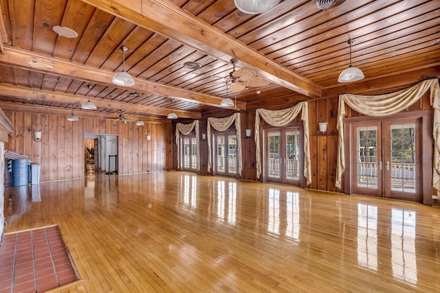 exercise area with french doors, wood ceiling, light wood-type flooring, and wooden walls