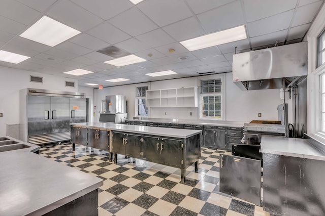 kitchen featuring ventilation hood and a drop ceiling