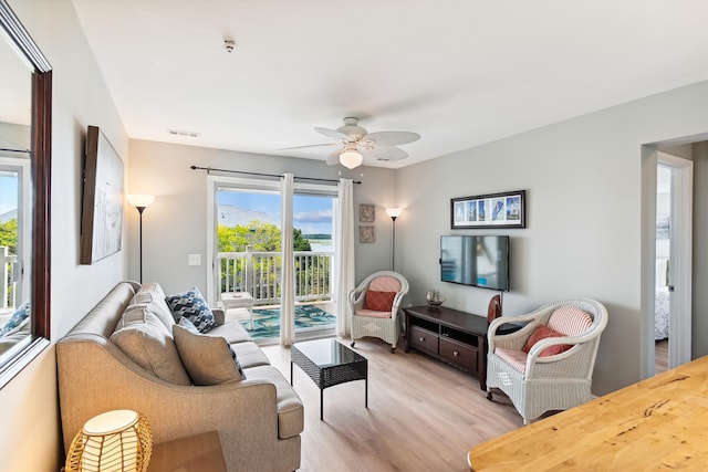 living room with light hardwood / wood-style floors and ceiling fan