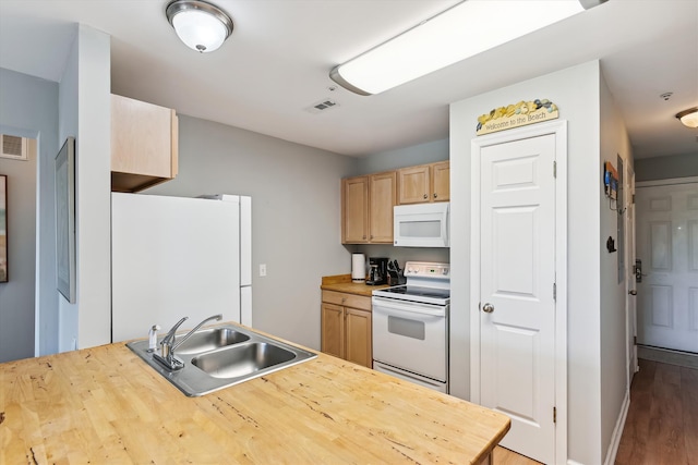 kitchen with sink, white appliances, hardwood / wood-style floors, and light brown cabinetry