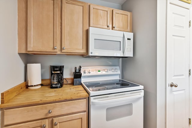 kitchen with butcher block counters, light brown cabinets, and white appliances