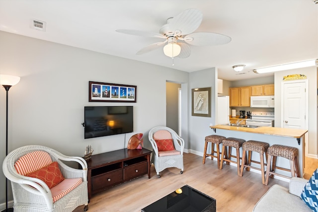 living room with light wood-type flooring and ceiling fan