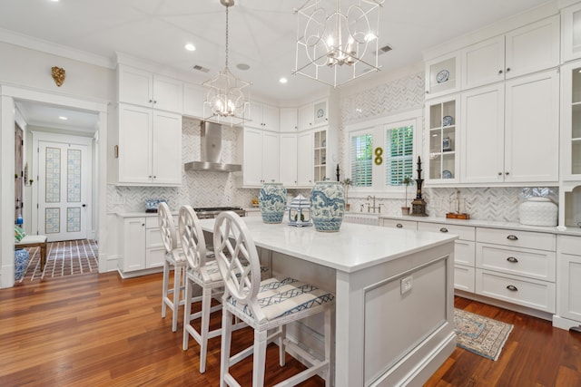 28 Robert Mills Cir, Mount Pleasant, SC 29464 - kitchen featuring wall chimney exhaust hood, a chandelier, crown molding, a center island, and light countertops