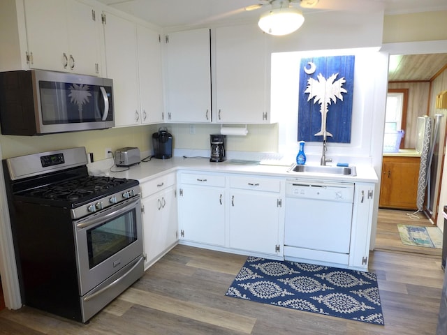 1001 Palmetto Blvd, Edisto Island, SC 29438 - kitchen featuring stainless steel appliances, light wood-style floors, light countertops, and white cabinetry