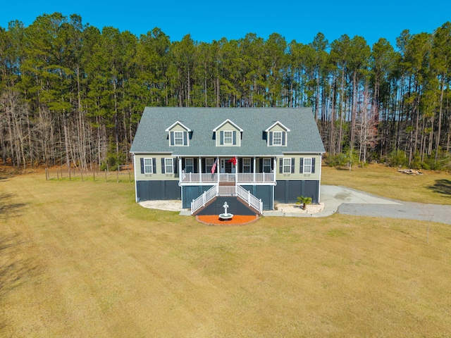 view of front facade featuring stairs, a porch, a front lawn, and driveway