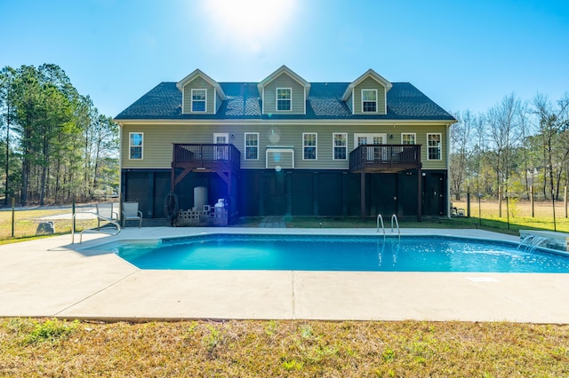 rear view of house featuring an outdoor pool, a balcony, and a patio area