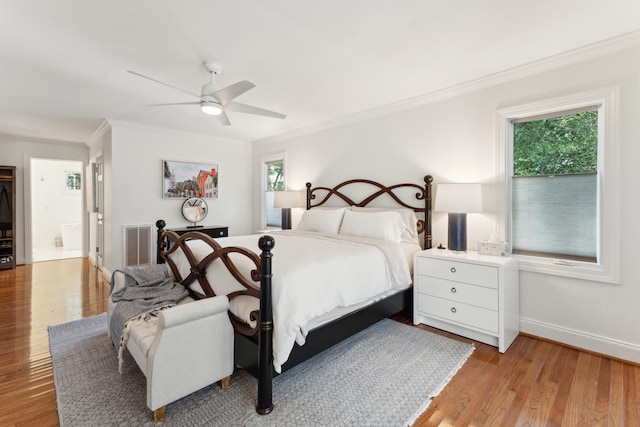 bedroom with ceiling fan, light wood-type flooring, ornamental molding, and connected bathroom