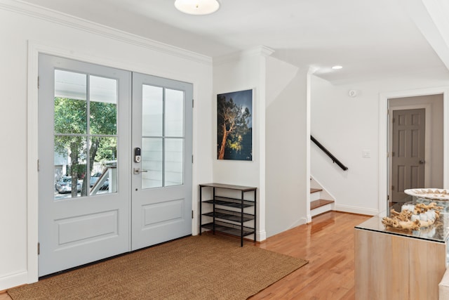 entrance foyer with hardwood / wood-style floors, french doors, and ornamental molding