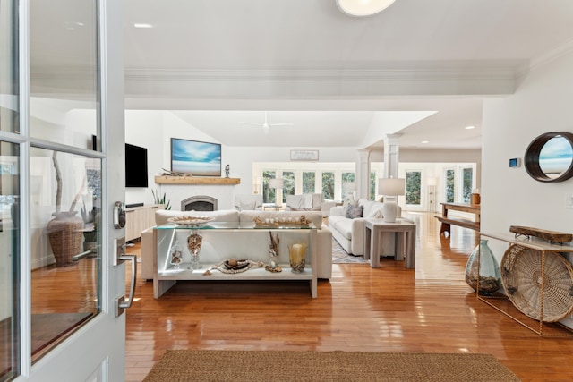 interior space featuring decorative columns, light hardwood / wood-style flooring, and ornamental molding