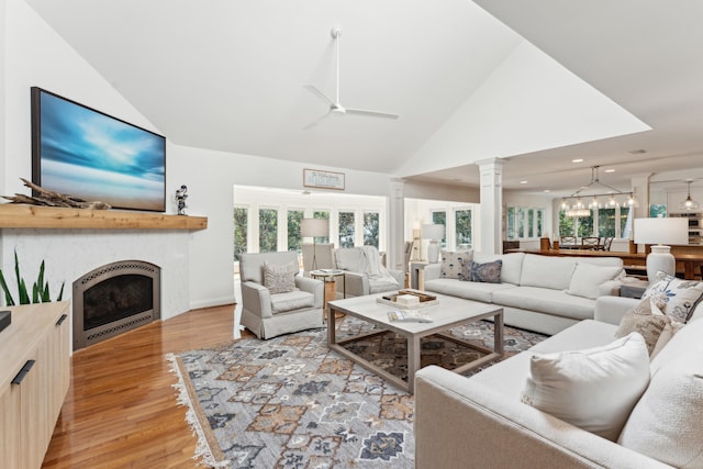 living room with ceiling fan, high vaulted ceiling, and light hardwood / wood-style floors