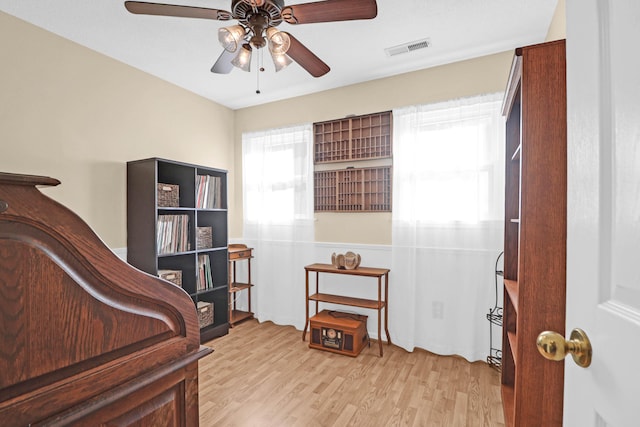 bedroom featuring light wood-style flooring, visible vents, and a ceiling fan