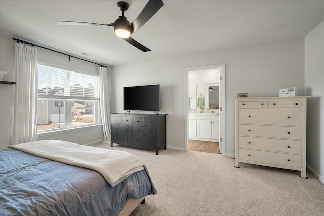 bedroom with light carpet, ceiling fan, and ensuite bathroom