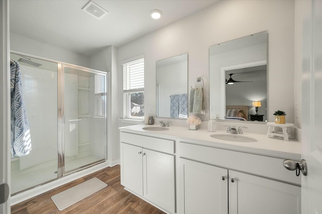 bathroom with a shower with shower door, vanity, ceiling fan, and hardwood / wood-style flooring