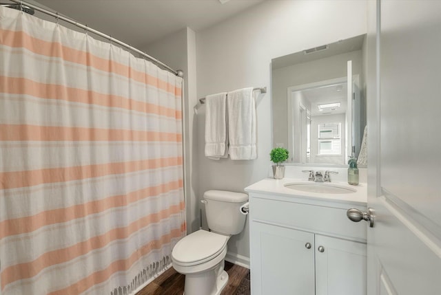 bathroom featuring toilet, vanity, wood-type flooring, and walk in shower