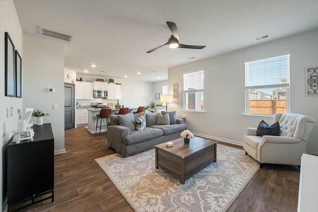 living room with ceiling fan and dark hardwood / wood-style floors