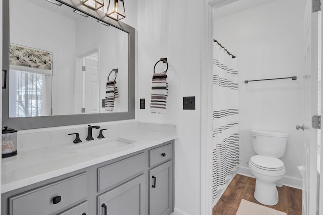 bathroom featuring wood-type flooring, vanity, toilet, and curtained shower