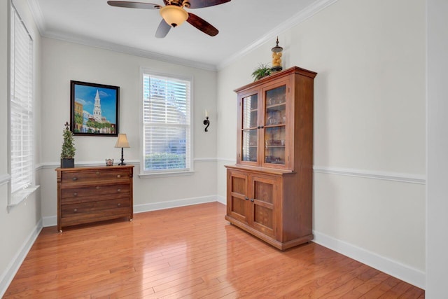 interior space featuring light wood-type flooring, ceiling fan, and ornamental molding