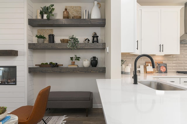 bar with white cabinets, dark hardwood / wood-style floors, sink, and tasteful backsplash