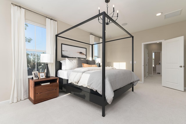 bedroom featuring light carpet and an inviting chandelier