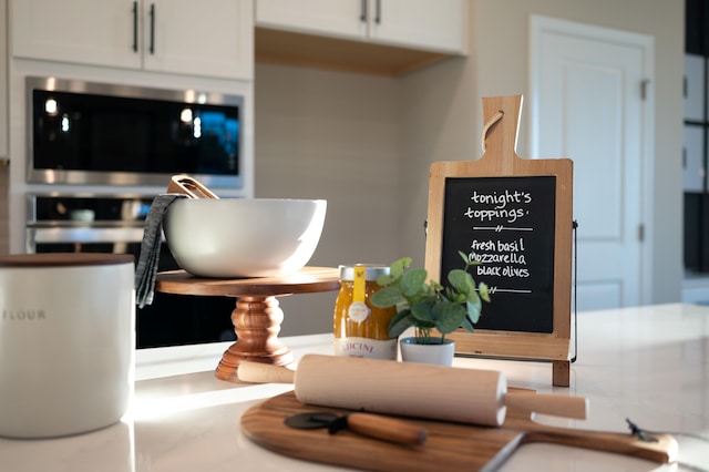 room details featuring stainless steel microwave and white cabinetry