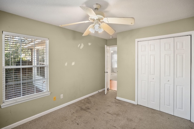 unfurnished bedroom featuring ceiling fan, a closet, and carpet