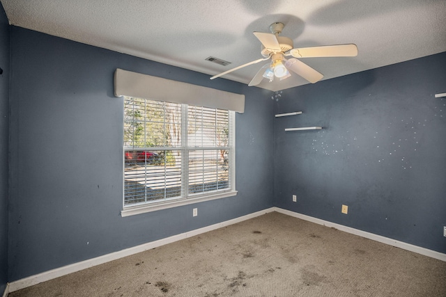 carpeted spare room with a textured ceiling and ceiling fan