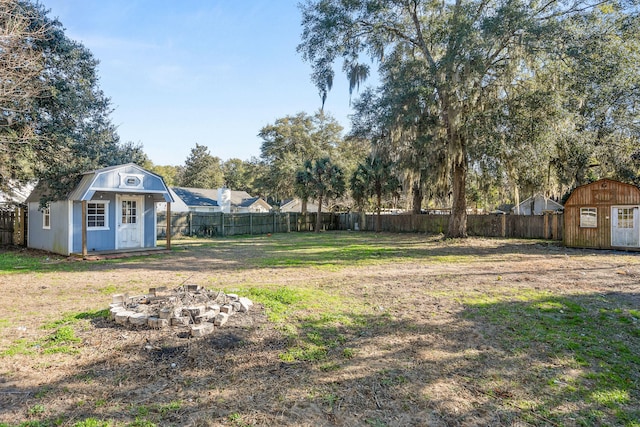 view of yard with a fire pit and a storage unit