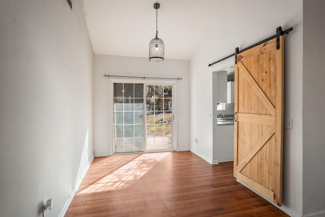 doorway to outside featuring dark wood-type flooring, a barn door, and sink