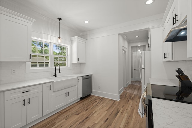 kitchen featuring stainless steel appliances, under cabinet range hood, a sink, white cabinets, and backsplash
