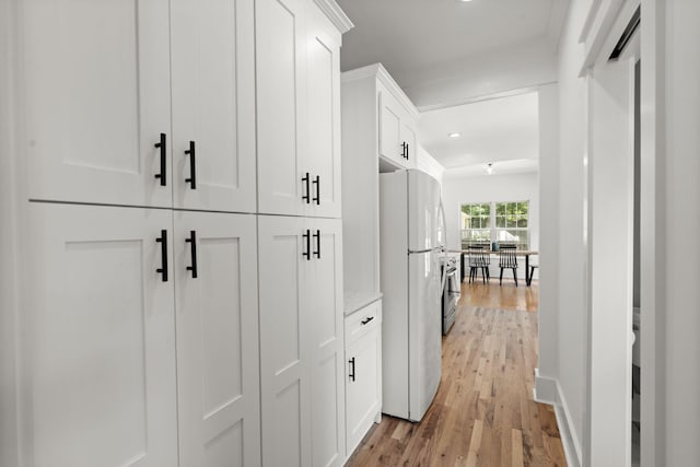 hall with light wood finished floors and recessed lighting