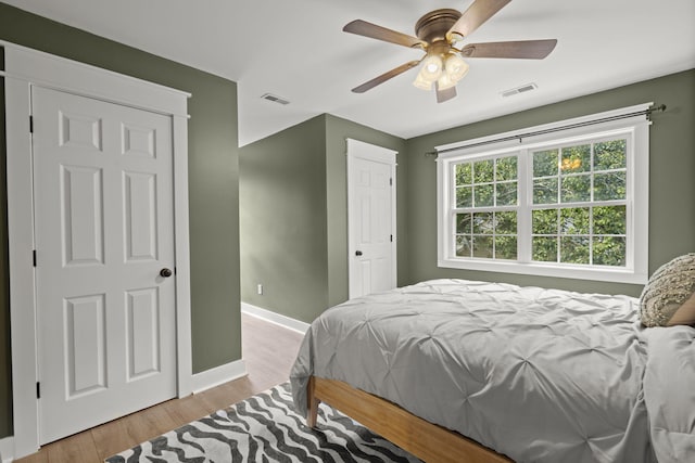 bedroom with baseboards, light wood-style flooring, and ceiling fan
