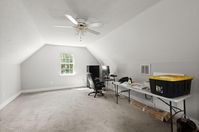 carpeted home office with a textured ceiling, vaulted ceiling, baseboards, and a ceiling fan