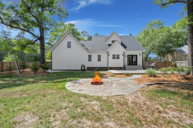 back of property featuring a fire pit, a patio area, and a shingled roof