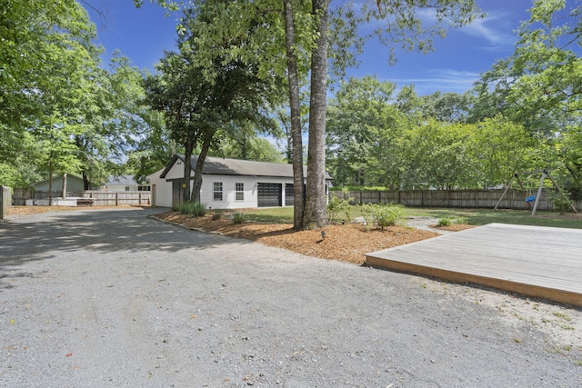 view of front of house with a fenced backyard, a wooden deck, and a playground