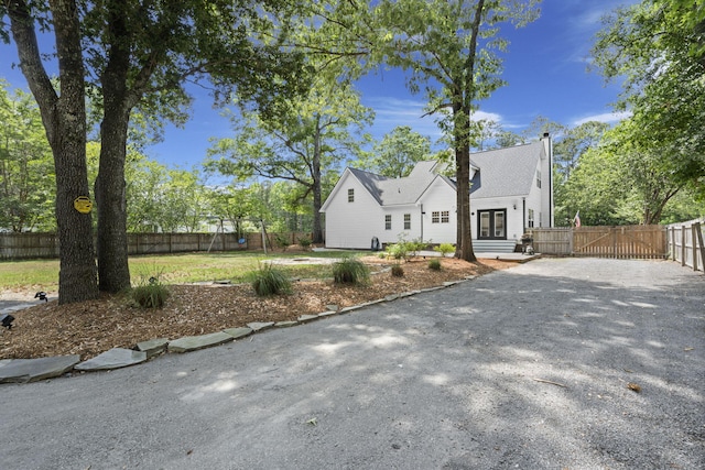 view of front of house featuring gravel driveway, a gate, and fence