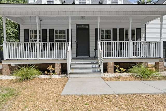 view of exterior entry with a porch