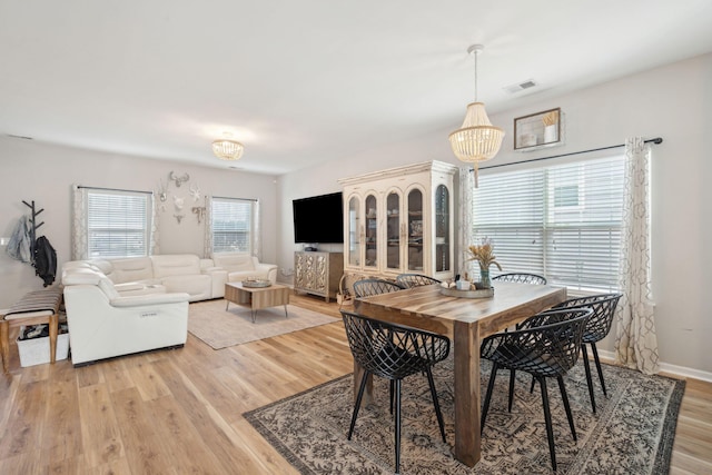 dining area with a notable chandelier and light wood-type flooring