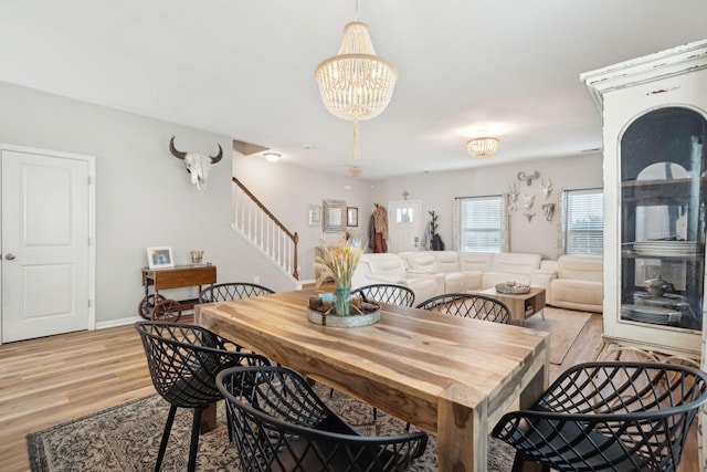 dining area with a notable chandelier and light hardwood / wood-style flooring