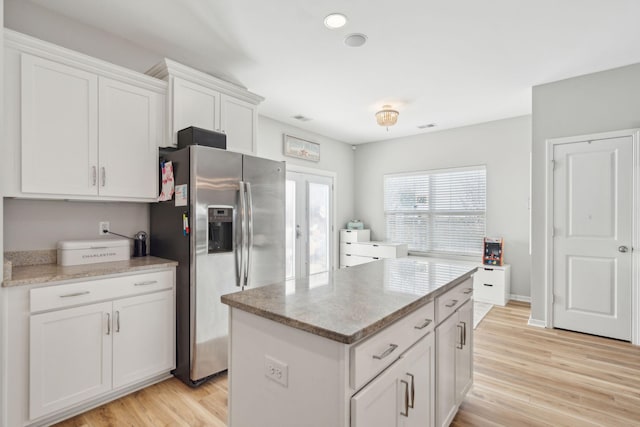 kitchen featuring white cabinetry, a center island, light hardwood / wood-style floors, stainless steel fridge with ice dispenser, and french doors