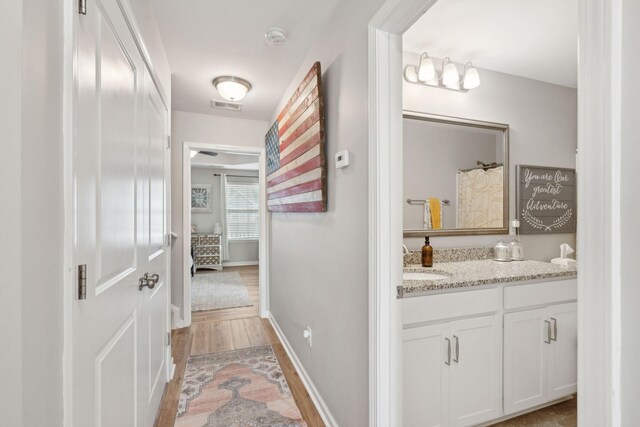 bathroom featuring a shower with curtain, vanity, and wood-type flooring