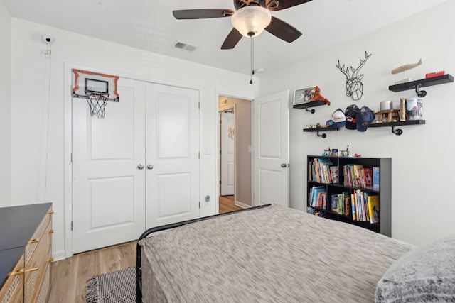 bedroom with ceiling fan, a closet, and light hardwood / wood-style flooring