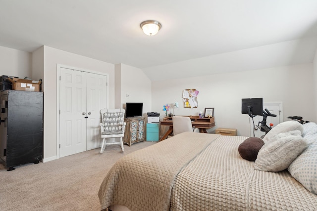 bedroom with lofted ceiling, a closet, and carpet