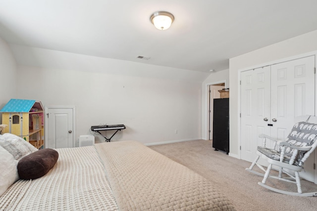 carpeted bedroom featuring lofted ceiling and a closet