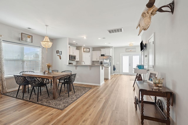 dining area featuring light hardwood / wood-style flooring and french doors