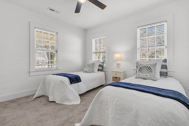 carpeted bedroom featuring visible vents, baseboards, and a ceiling fan