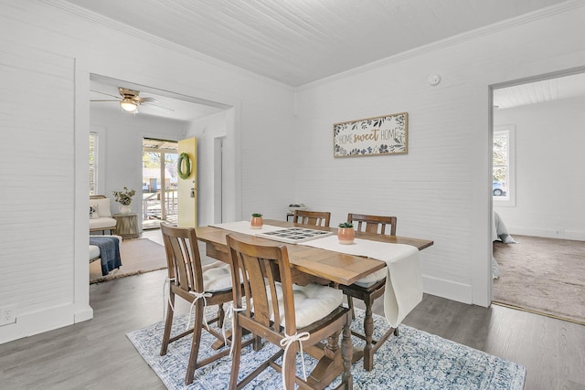 dining room featuring crown molding, wood finished floors, baseboards, and ceiling fan