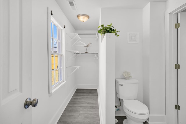 bathroom featuring visible vents, a healthy amount of sunlight, baseboards, and wood finished floors