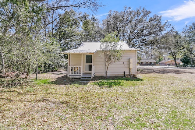 view of front of property with metal roof and a front lawn